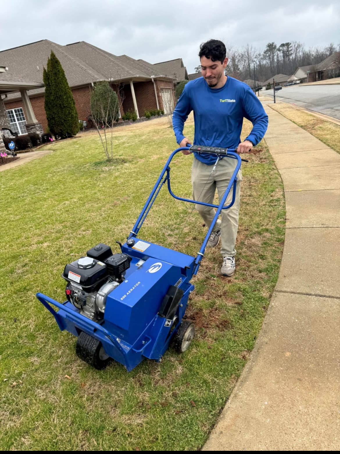 Turf Titans crew running a core aerator on a lawn in Meridianville, AL