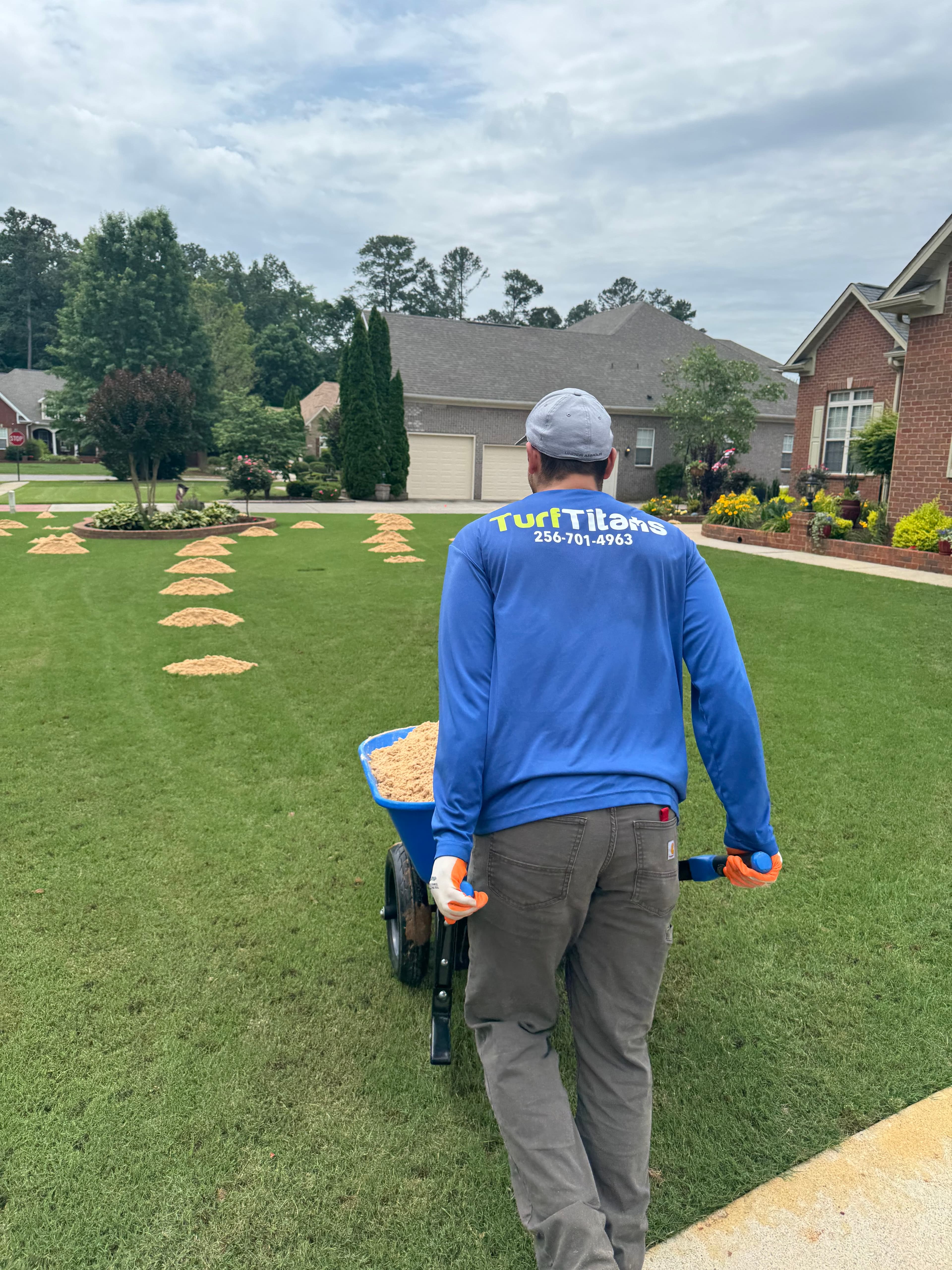 Turf Titans crew spreading top dressing sand on a lawn in Meridianville, AL
